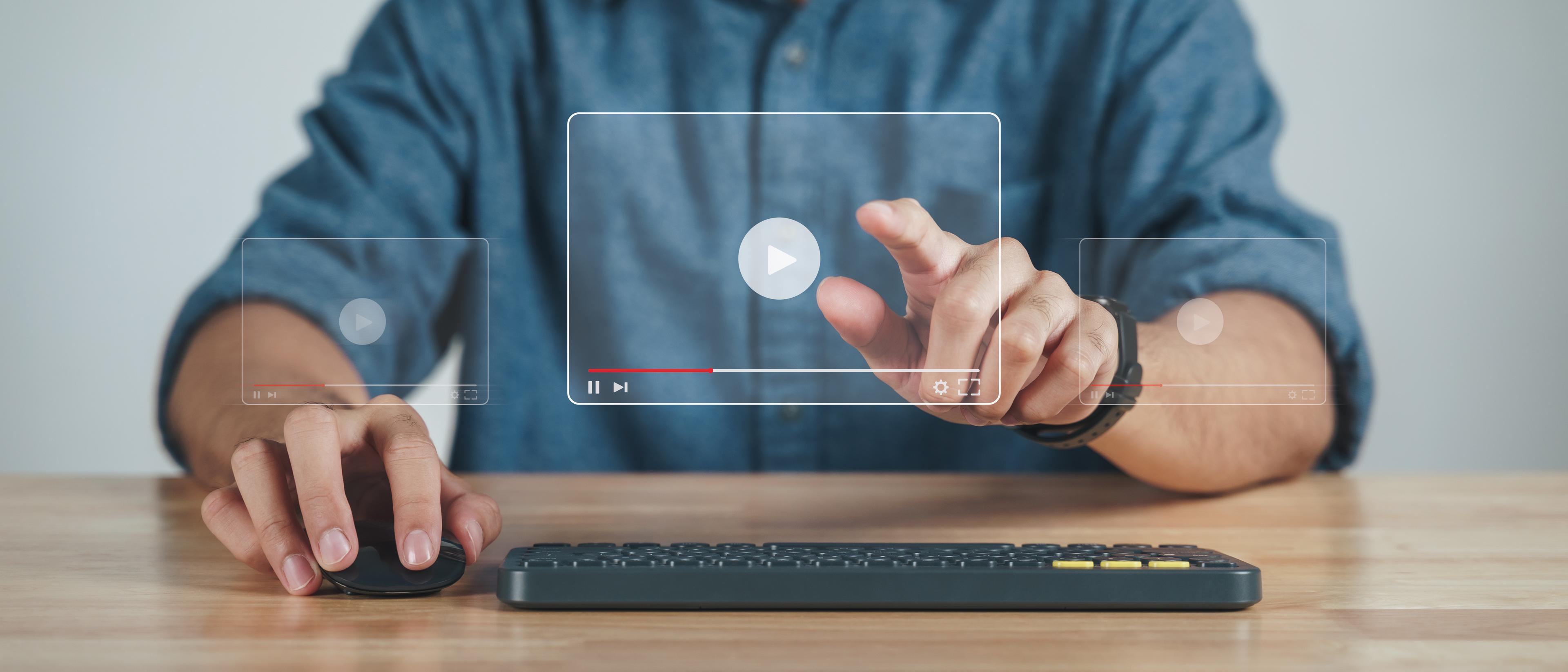 Transparent computer screen with man pointing finger to play a video